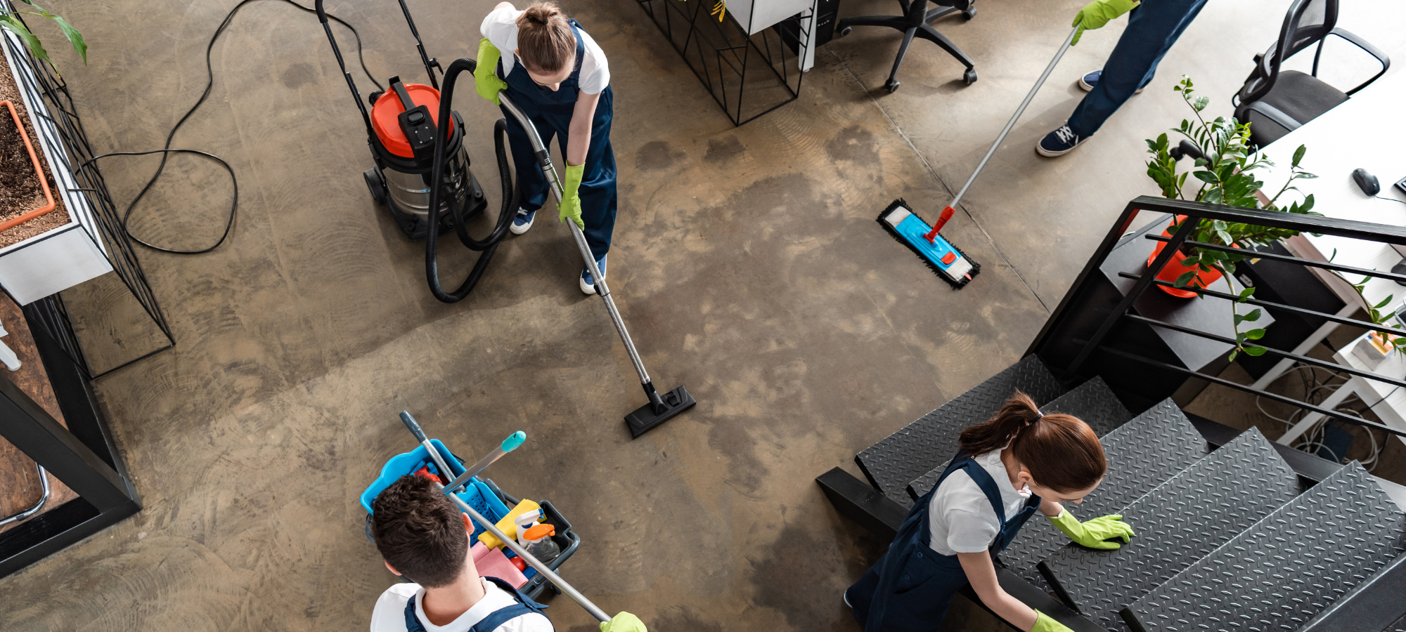 Professional cleaning crew vacuuming and mopping an office space after renovation, preparing it for handover